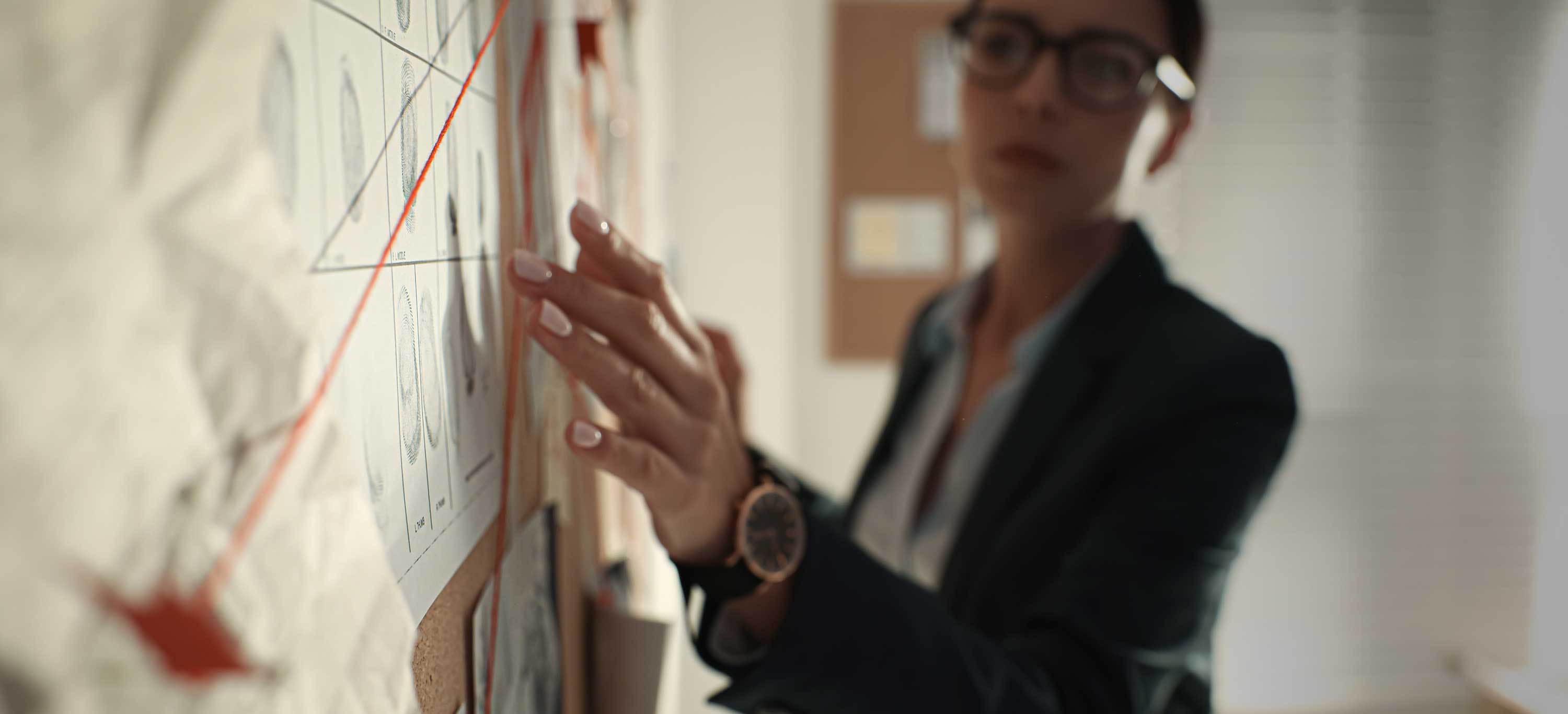 woman examining evidence board